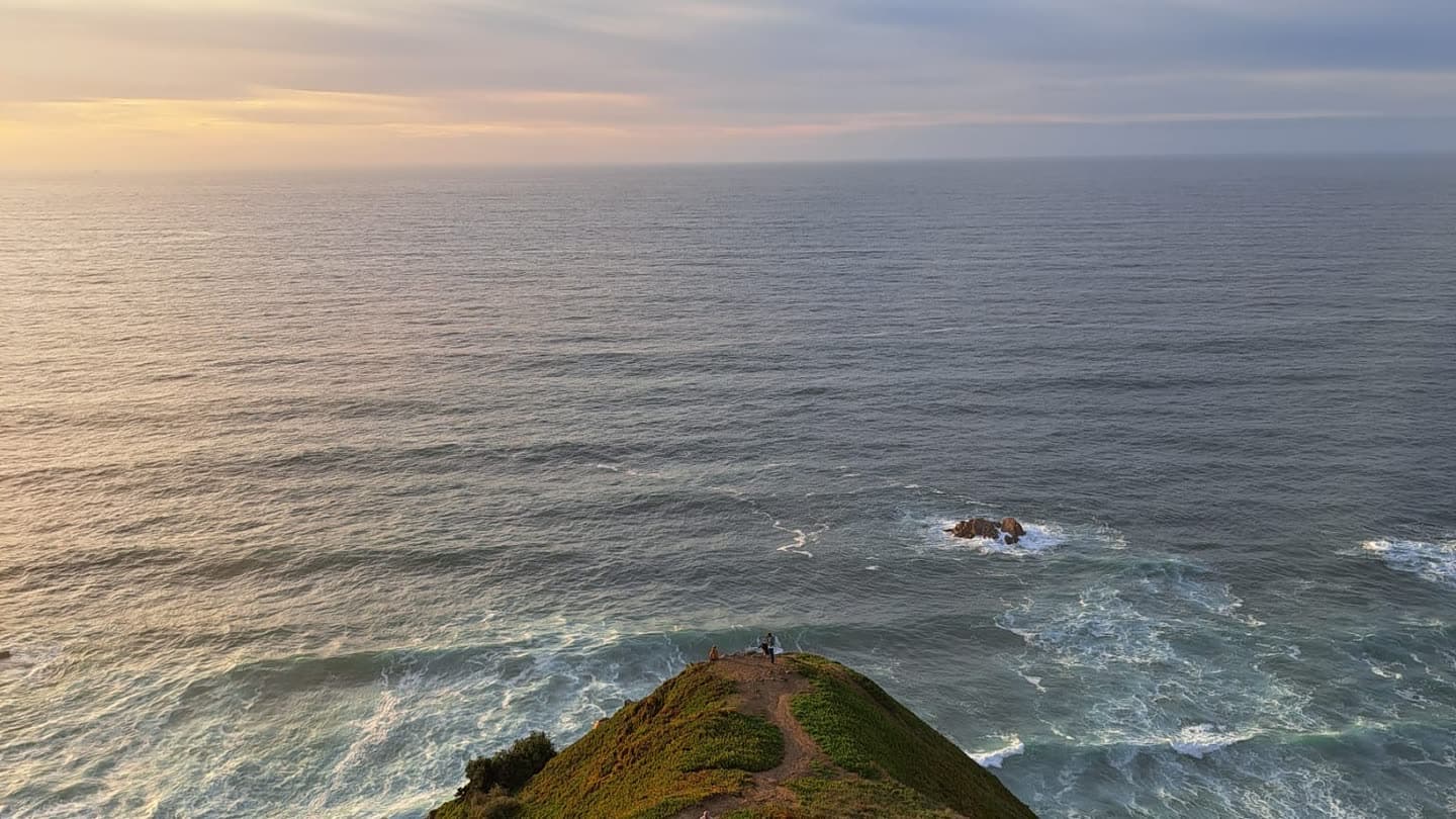 A narrow path running out along a headland to a cliff edge above the Atlantic at dusk