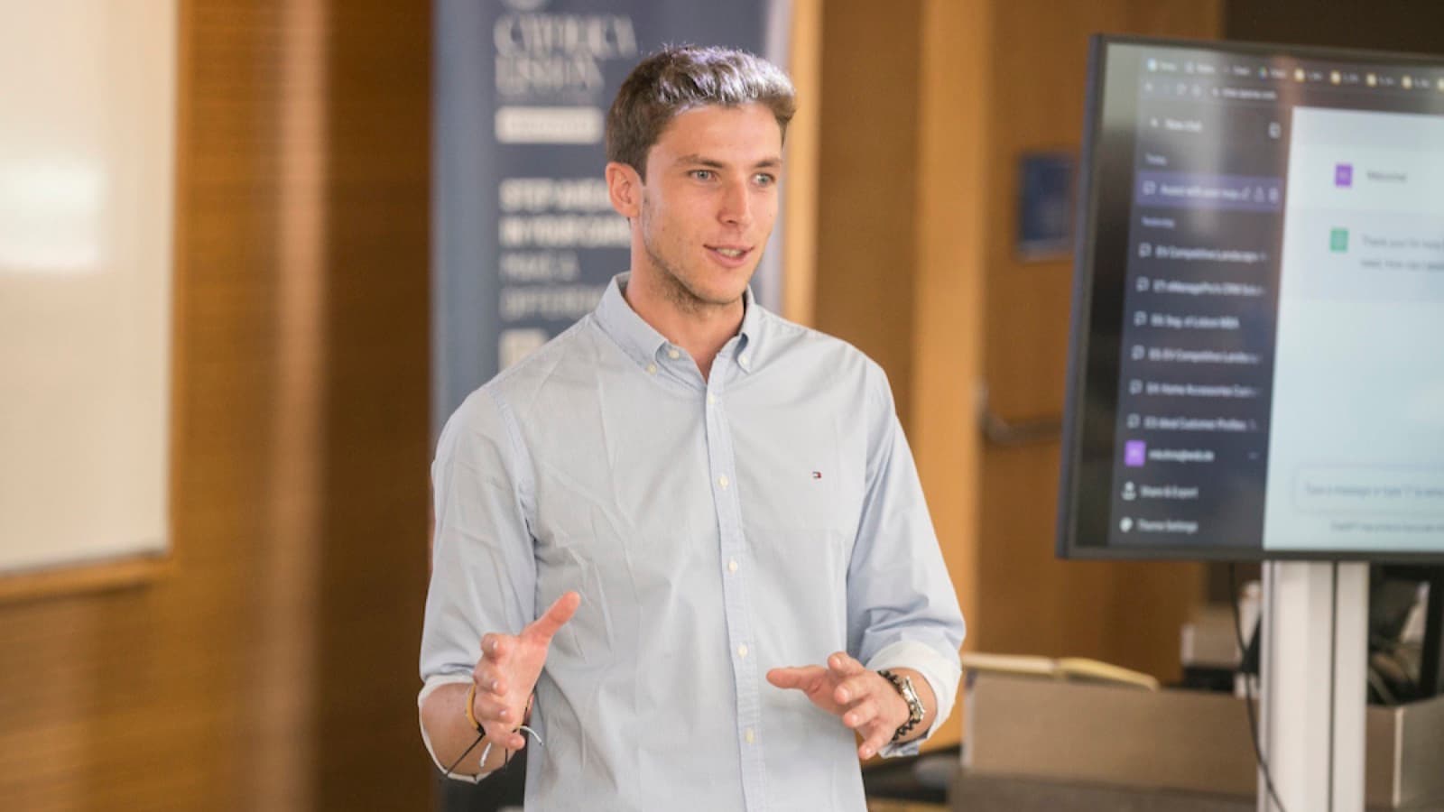 Marco Kohns teaching an AI seminar at CATÓLICA-LISBON, a chat interface projected behind him