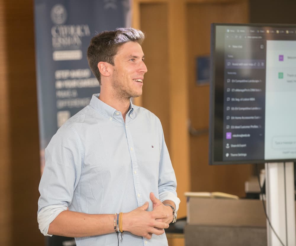Marco Kohns teaching an AI and growth marketing session at Católica Lisbon, with a ChatGPT interface on the screen behind him
